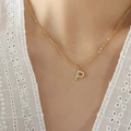 Pendant necklace with letter P in gold finish and zircon stones on a model - Letter P / Gold