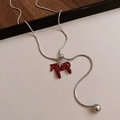 Detail view of a red horse pendant on a silver snake chain with a gold star charm - 18# Necklace-Silver-Red