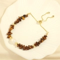 Detailed close-up of tiger eye stone bracelet with large freshwater pearl and golden toggle - Tiger Eye