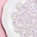Vue macro de perles en acrylique 16mm peintes ciel étoilé avec motifs floraux - Fleur Blanche Point Violet / 16mm Lumineux