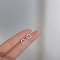 Delicate 925 sterling silver twist stud earrings shown on fingertip for size reference - Entwined Ring / Silver