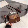 Gros plan d'un sac besace marron avec texture crocodile et fermoir doré chic - Avec Pendentif / Marron