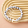 White turquoise beaded bracelet with a cross charm on a decorative display stand - White Turquoise Black Vein Beige Cross