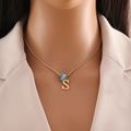 Detail of gold necklace with blue evil eye bead and letter S pendant on a mannequin - Letter S (N1339)