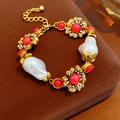 Baroque pearl bracelet with red gemstone flower charms on a vintage jewelry box - Bracelet-Gold-Pink