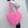 Furry heart-shaped crossbody bag in bright pink faux fur styled with casual outfit - Barbie Pink