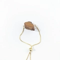 Detail of adjustable golden box chain with raw natural brown crystal mineral stone - Tiger Eye