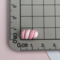 Vista dettagliata di un ciondolo in resina a spirale rosa e bianco su un righello a griglia - Marshmallow-Rosa Bianco
