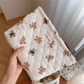 Nahaufnahme der gesteppten Kosmetiktasche mit Bärenmuster und Simple Wish Label im Haus - Gestreifter Bär