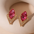 Macro shot of gold geometric earrings with rose red crystals and white rhinestones - Irregular Triangle Silver Pin Style / Pink