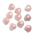 Primer plano de diez piedras de cuarzo rosa pulido en forma de corazón en fondo blanco - Cuarzo rosa