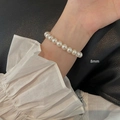 Detail showing 8mm cream pearls on a flexible elastic bracelet worn on a wrist - 8mm Pearl Bracelet