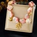 Primer plano detallado del collar de conchas con dijes de estrellas de mar doradas - Collar Estilo Océano (N3572)
