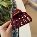 Close-up of a large burgundy pumpkin hair claw clip made of glossy resin with metal spring - Ancorra Red