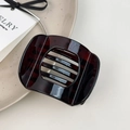 Detail of square dark tortoiseshell hair clip with cut-out design on a ceramic plate - Small Deep Coffee