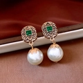 Close-up of vintage style gold-toned earrings with green square gems and round pearls - 925 Silver Pin Pearl Earrings-Gold-White