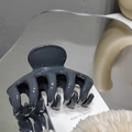 Detailed view of glossy dark gray hair claw clip on a reflective mirror surface - Gray Blue
