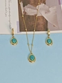 Golden necklace and earring set featuring oval turquoise pendants on a blue backdrop - Gemstone Style / Turquoise Green Blue