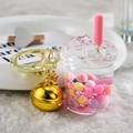 Close-up of a bubble tea keychain with colorful moving balls and a large gold bell - Style with Bells / Pink