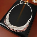 Detail of tear-drop pink rhinestone necklace with adjustable lobster clasp on black pad - Purple