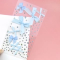 Close-up of light blue fabric bows and iridescent rhinestones for facial makeup and eye art - BJA-638 (Blue Bow Tie)