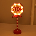 Red wooden Santa Stop Here LED sign with warm lights and festive red ribbon bow decor - Octagonal