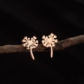 Rose gold dandelion earrings on a natural wood branch against a black background - Dandelion Rose Gold