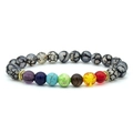 Colorful chakra energy bracelet with natural volcanic stones and golden spacers on white backdrop - Dragon Pattern Colorful Chakra Bracelet