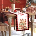 Kerst tafelloper met peperkoekhuisje en rood ruitpatroon op een feestelijk versierde houten tafel - Peperkoekhuisje