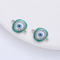 Detailed close-up of teal enamel evil eye charm with rhinestones and double-ring connectors - Silver Tone + Lake Blue