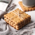 Three-piece set of light wood cookie-shaped coasters with wave edges and twine wrapping - Beech Square Biscuit Coaster