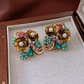 Detalle de pendientes vintage dorados con perlas y piedras en un estuche de madera - Pin de plata 925 / Dorado