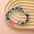 Detailed view of colorful ink-patterned turquoise beads with a pink cross pendant - Multi-color Splatter Pink Cross Bracelet