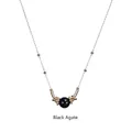 Detail of delicate gold necklace featuring black agate bead and polished gold ring accents - Black Agate-Gold Chain