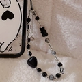 Detail of beaded phone strap with black heart and bear charms on plush background - Heart Bear Black Lanyard