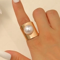Gros plan d'une large bague en métal doré avec une grande perle blanche sur la main - Or Large Imitation Perle (4232)