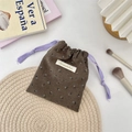 Detailansicht der Cord-Beutel mit Blumenmuster, Sezakka-Label und lila Kordelzug - Cord Wildblumen Kaffee