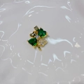 Golden four-leaf clover pendant featuring green heart-shaped gems and small sparkling crystals - Green Clover