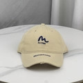 Detail of embroidered 'M' and 'EU 1986' letters on a beige distressed baseball cap - One Size (58-60cm) / Khaki