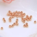 Vue macro de perles rondes en or rose avec trous pour la création de bijoux DIY - 2.5mm (Trou de 1.0mm) / Or rose