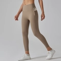 Close-up of high-waisted yoga pants with side pocket holding a smartphone in khaki - Cocoa