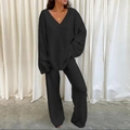 Detail of elegant black V-neck knit top and wide-leg trousers set with soft drape texture - Black