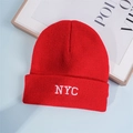 Close-up of white NYC embroidery on red ribbed knit beanie hat with premium stitching - One Size / Red