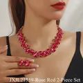 Close-up of a model wearing rose red teardrop crystal necklace and earring set - Rose Red Acrylic 2-Piece Set