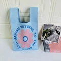 Light blue knitted tote bag featuring a pink sunflower pattern and stylish typography - Blue Daisy Flower