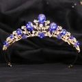 Detalle de corona dorada con piedras azules y diamantes de imitación en terciopelo - Diamante de Imitación Azul Zafiro / KC Oro Diamantes de Imitación Claros y Azules