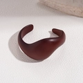 Macro detail of dark reddish-brown acrylic cuff with minimalist organic curved lines - 6# Streamlined Spiral Open (Chestnut Red)