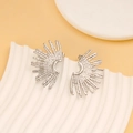 Detailed view of silver fan-shaped earrings with unique hammered texture on a white stand - Silver