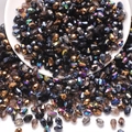 Detailed view of faceted teardrop glass beads in black gold and iridescent colors - Black Series