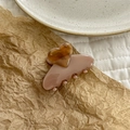 Detail of elegant pink acetate hair claw clip with a small amber heart on paper - Pink Brown